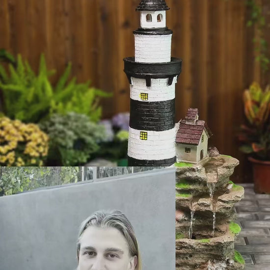 FountJoy lighthouse fountain bringing coastal charm to your backyard — water cascades over textured rocks past a charming lighthouse while LED lights create a magical nighttime glow. A conversation-starting garden fountain for any patio setting.